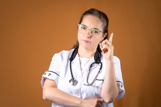 Mujer doctora con cara seria y una expresi&oacute;n de advertencia.