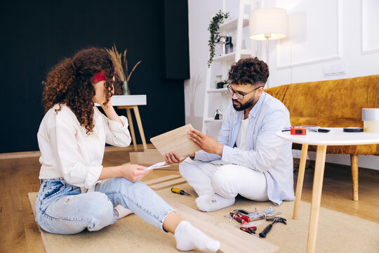 Couple assembling flat pack furniture blindfolded in new apartment