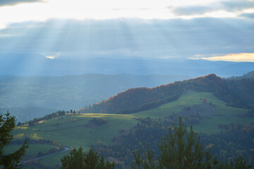 Sunbeams lighting up green mountain pastures during autumn sunset in Pieniny. © denfotoblog
