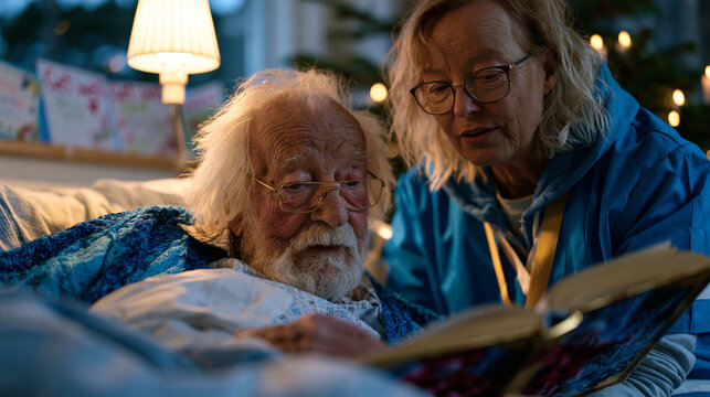 Volunteer visitor reads aloud from a hardcover book to a bedridden elderly man in a hospital room, bedside lamp casting warm candlelit atmosphere, get-well cards arranged on the window ledge, the vo