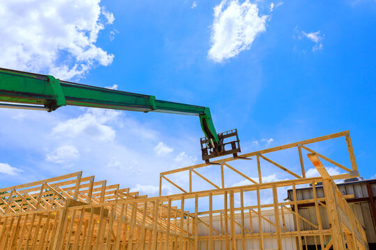 Construction site crane lifting wood beams into position