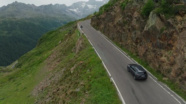 Aerial view of a car driving along the High Alpine Road in Austria. A dangerous mountain road featuring hairpin turns and beautiful natural scenery; travel and tourism in Europe.