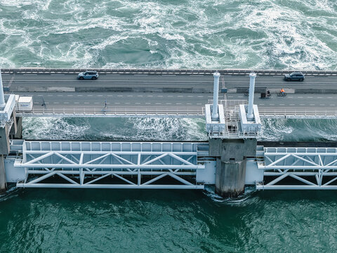 Oosterscheldekering storm surge barrier protecting The Netherlands, cars and cyclists using the road on top