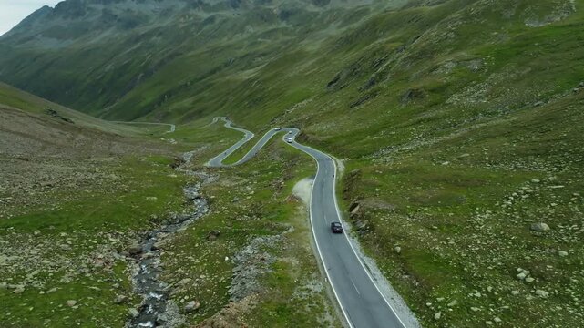 Aerial view of a car driving along the High Alpine Road in Austria. A scenic mountain road for tourists in Tyrol; traveling through Europe.