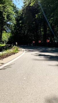 convertible car in sunny nature on a bright summer day. wide angle pursuit shot - vertical video for reels and story
