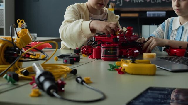 Multiethnic children building and programming robotic models in STEM classroom. Footage is perfect for promoting modern science education and technology camps