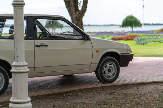 Lada Samara 1300 Sputnik VAZ-2108 - side profile view of a light beige or white vintage soviet car parked on a lakeside park walkway in Palic, Serbia on July 5, 2026