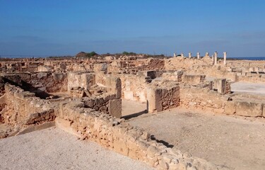 Obraz premium Ancient archaeological ruins at Paphos Archaeological Park, Cyprus – historic Roman city remains under clear blue Mediterranean sky