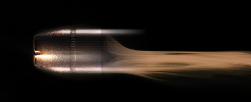 Orange and yellow smoke behind a speeding pistol bulilet