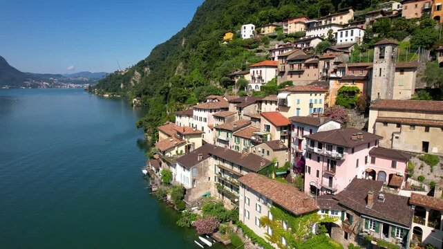 Cinematic Sweeping Aerial Drone Panning Shot Gandria Village Lake Lugano Switzerland Right to Left Reveal Entire Historic Lakeside Settlement Cascading into Water Swiss-Italy Border Summer 4K Travel