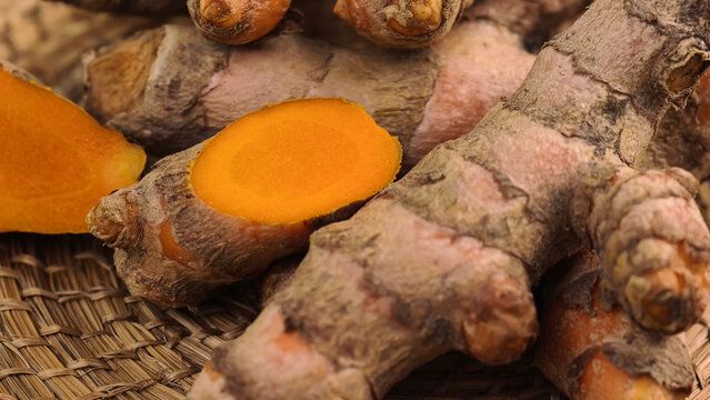 Fresh Turmeric Rhizomes in a Woven Basket on a Wooden Table