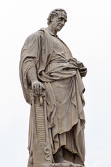 Fototapeta premium Statue of Alessandro Volta holding a Book and Voltaic Pile on a White Background. Como city Italy. Italian physics