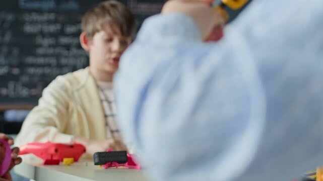 Caucasian boy assembling robotic components during STEM class in school. Footage is suitable for promoting elementary science education and after-school technology programs