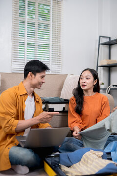  The couple is planning their trip and booking accommodations online while sitting at home on the sofa. They use their laptops to plan their itinerary, check flights, and book hotels.