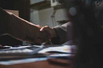 Fototapeta premium Business partners shaking hands over documents during meeting