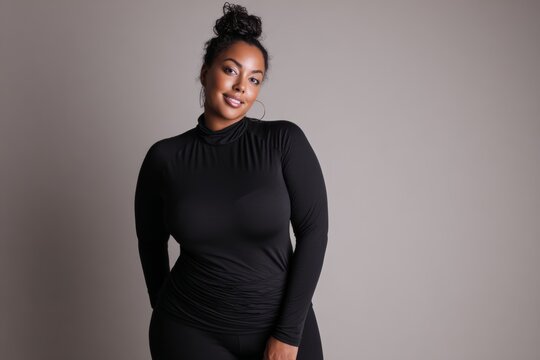 diverse plus-size woman standing confidently in a minimalist studio, wearing stylish, form-fitting clothing and looking directly at the camera with a smile. Neutral background, soft natural lighting. 