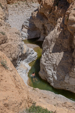 An unidentified young man swimming in Nahal Rahaf-Rahaf Stream in the Judean Desert in Israel.

