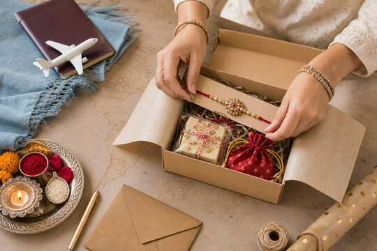 Sister packing rakhi parcel for brother abroad on Raksha Bandhan