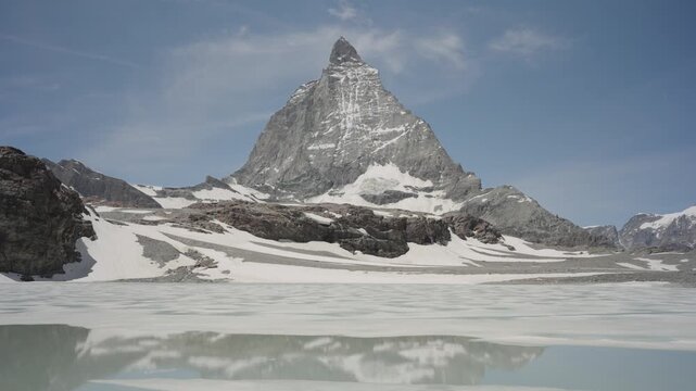 Majestic matterhorn peak reflecting in the melting alpine lake riffelsee during a sunny day