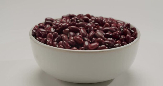 Raw, dry red kidney beans slowly rotating in a captivating macro view, showcasing their rich color and smooth texture in a beautiful, natural, and healthy food concept display. Dry red kidney beans