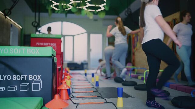 Young children actively participate in dynamic fitness activities, enhancing their physical development. Kids enjoy an engaging workout, developing balance and agility in a specialized indoor gym.