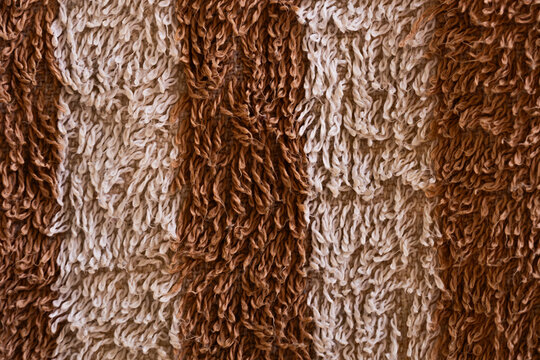 Close-up of striped brown and beige shag rug texture background