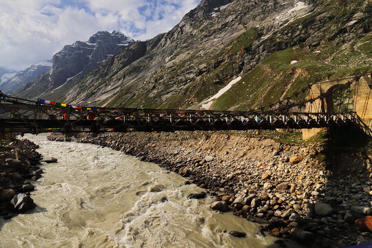 old cable stayed bridge over chandra or chenab river, scenic mountain landscape of chhatru campsite area of hampta pass trek, explore himalayas, lahaul valley in himachal pradesh, india
