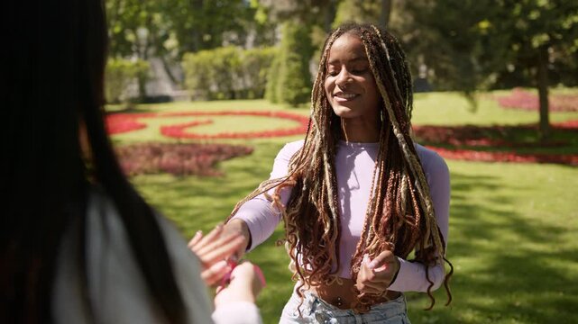 African american woman receiving pink ribbon in park