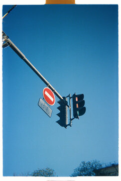 Traffic lights and road signs seen against a clear blue sky