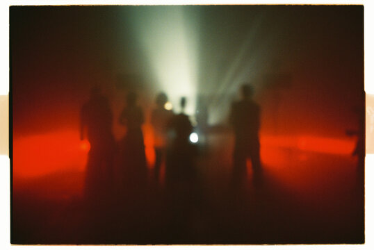 Night party crowd dances in dim light during a club music event