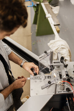 Artist working with framing machinery in a workshop