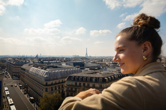 Smiling traveler overlooking Paris from above