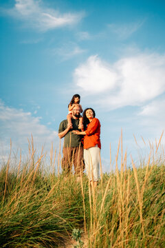 Family Enjoys a Day Outdoors on a Sunny Beach With Grass