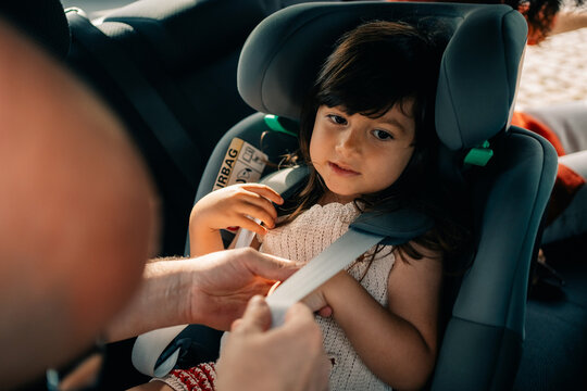 Child in Car Seat Getting Safety Belt Fastened During a Trip
