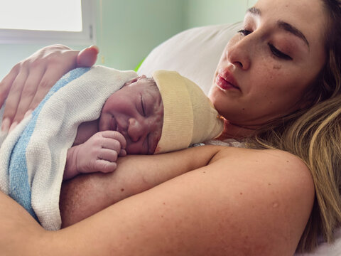 Mother holding newborn baby after birth in hospital