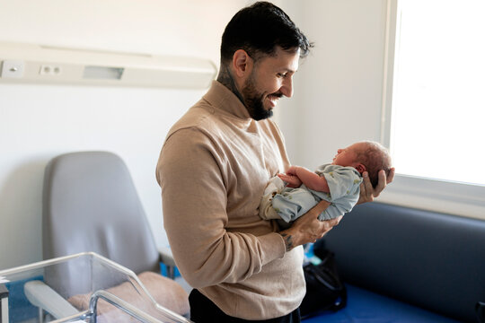 Happy father bonding with newborn baby in hospital