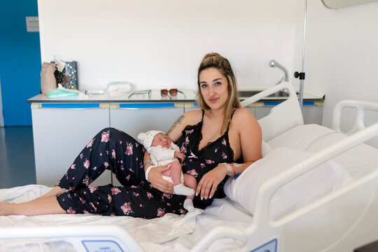 New mother bonding with newborn baby in hospital room