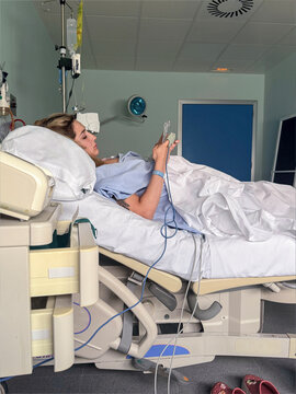 Woman patient using mobile phone in hospital bed
