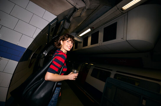 Woman Smiles While Waiting at a Subway