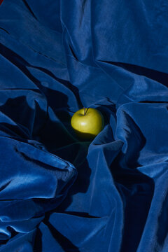 Single Green Apple Resting in Blue Velvet