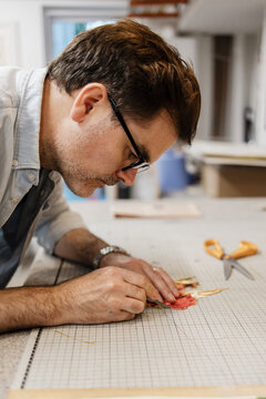 Artist creating detailed paper art in workshop