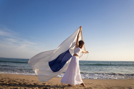 Woman walks on Beach With navigation flag