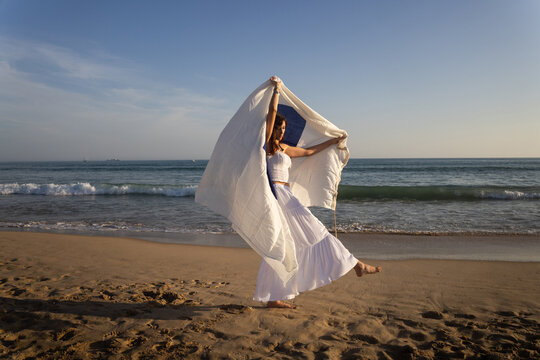 Woman Dances on Beach With navigation flag