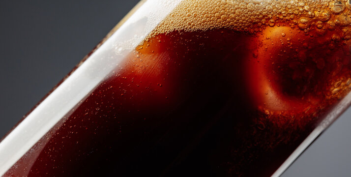 Coffee is poured into a glass with ice.