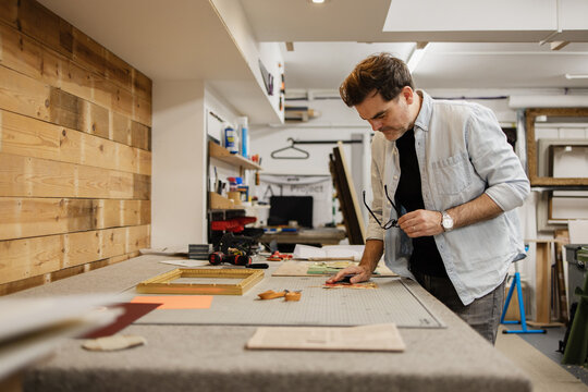 Craftsman working in his studio framing artwork