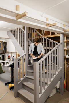 Artist sketching on stairs inside art studio workshop