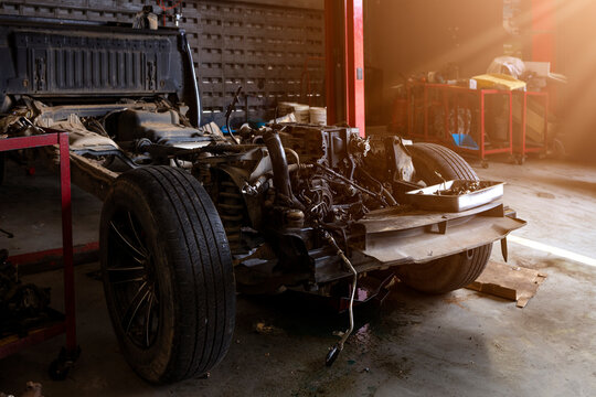 Disassembled Car Chassis with Engine Repair in Automotive Workshop Garage