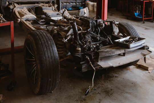 Disassembled Car Chassis with Engine Repair in Automotive Workshop Garage