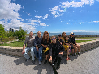 Fototapeta premium happy family portrait by lake ontario with toronto skyline, happy family taking selfie with toronto skyline and lake ontario in the background. summer day, travel, family vacation and outdoor lifestyl