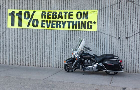 Motorcycle parked under a 11% rebate on everything sign at Menards lumber and hardware store. St Paul Minnesota MN USA